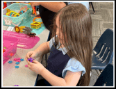 Child playing with colorful star-shaped toys at a table.
